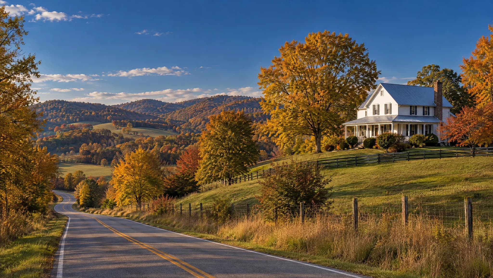 A country road through autumn hills past a white farmhouse